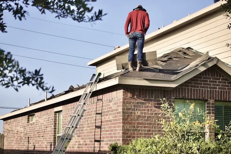 Professional roofer working on a residential roof in Westlawn